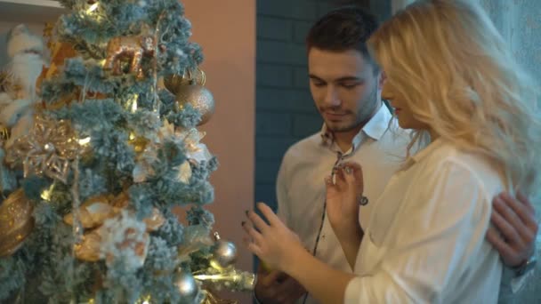 Jong Paar Verliefd Zetten Speelgoed Een Kerstboom — Stockvideo