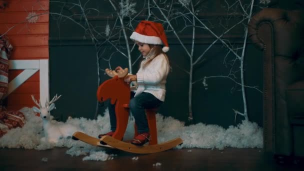 Meisje Rijden Een Speelgoed Paard Buurt Van Kerstboom — Stockvideo