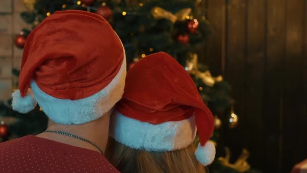 Real Time Couple Santa Claus Hats Laying Front Christmas Tree — Stock Video