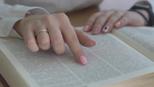 近距离拍摄的女人的手读一本书在室内 — 图库视频影像