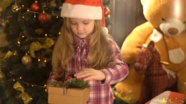 Bir çocuğun elinde bir Noel hediye kutusu.