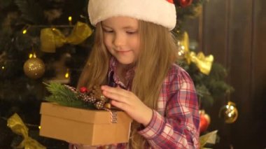 Bir çocuğun elinde bir Noel hediye kutusu.
