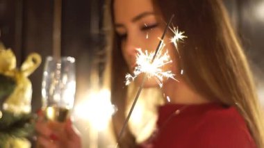 Sandalye de Sparkler, Bengal Holding Noel Ağacı yakınında Çekici Genç Kadın.