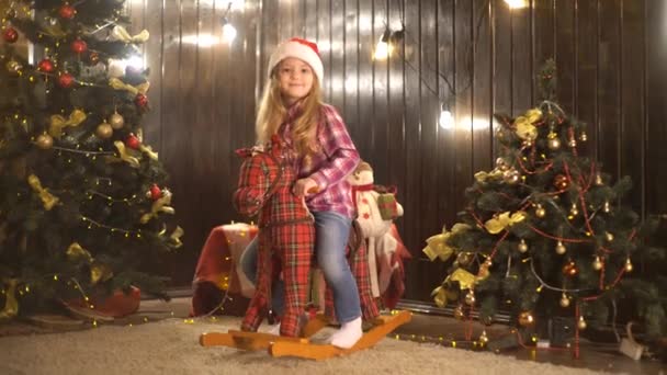 小さな女の子がおもちゃの馬に乗って — ストック動画