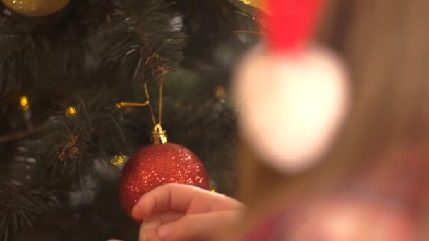 실내에서 크리스마스 트리를 장식하는 아이의 — 비디오