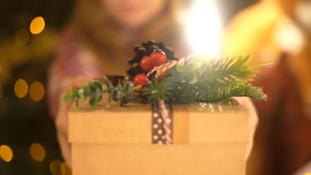 Schattig Meisje Een Kerstmuts Geeft Een Gouden Doos Met Lint — Stockvideo