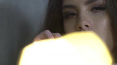 Yakın çekim yüz bir kızın parlak ışıklar ile.