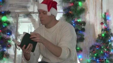 yakışıklı adam Noel hediye olarak kitap bakarak.