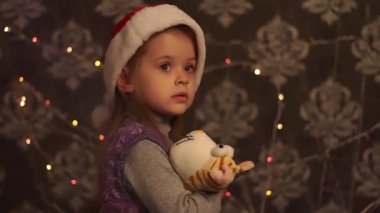 Sevimli küçük kız Noel Şapkasında Oyuncak Oynuyor.