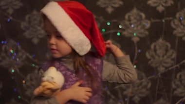 Küçük kız Noel ağacının yanında oyuncak ile oynuyor..