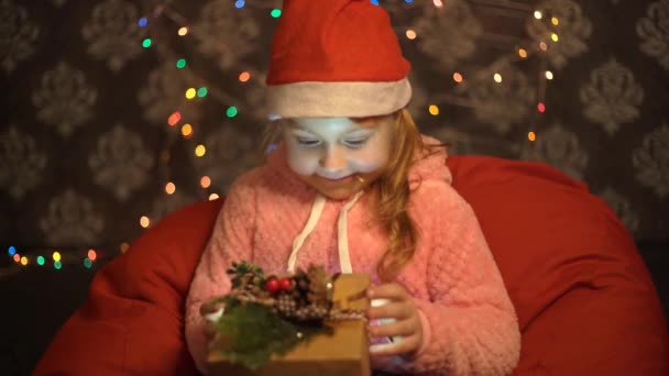 手にクリスマスプレゼント付きの小さな女の子の肖像 カメラを見て — ストック動画