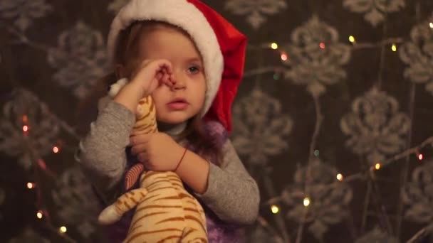 Weihnachtsmädchen Umarmt Spielzeug Trägt Weihnachtsmütze — Stockvideo