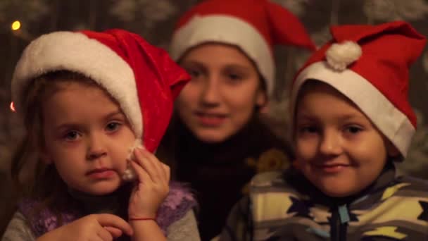 Kerstkinderen Met Kerstmuts Kijken Camera — Stockvideo