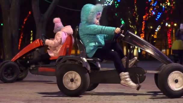 女孩们在圣诞节乘坐一辆小玩具车 — 图库视频影像