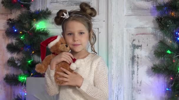 Mädchen Hält Teddybär Vor Geschmücktem Weihnachtsbaum — Stockvideo