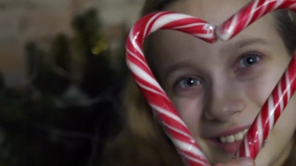 Kaukaska Dziewczyna Patrząc Przez Serce Kształt Candy Candy Canes — Wideo stockowe