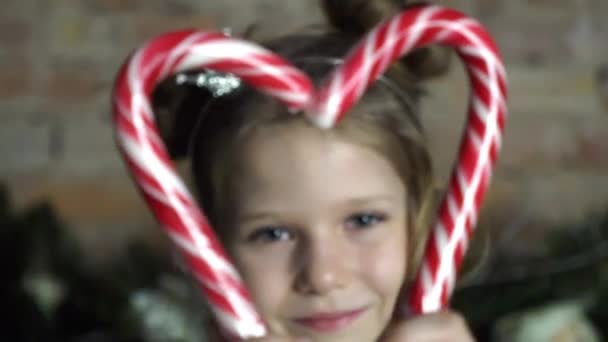 Kaukaska Dziewczyna Patrząc Przez Serce Kształt Candy Candy Canes — Wideo stockowe