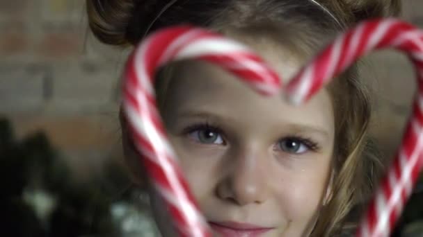Small Girl Holding Heart Made Two Candy Canes — Stock Video