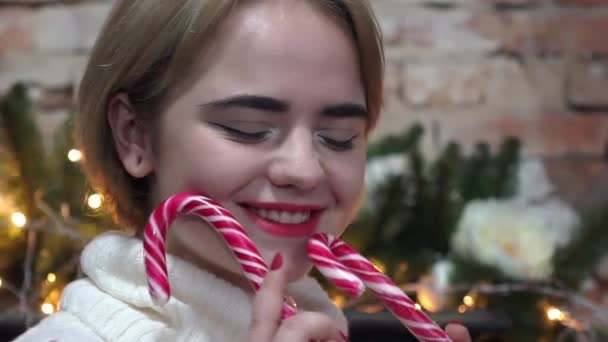 Διασκεδάζοντας Νεαρή Γυναίκα Κάνοντας Αστείο Πρόσωπο Χρησιμοποιώντας Lollypops Χριστούγεννα — Αρχείο Βίντεο