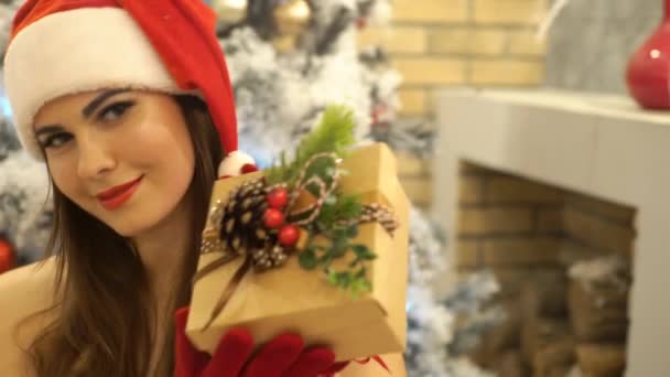 セクシーなサンタガールが微笑み カメラを見て サンタはプレゼントを与える — ストック動画