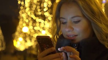 Mutlu Kız Noel Ağacına Karşı Gülümseme ile Akıllı Telefon Mesajı Okuyun.