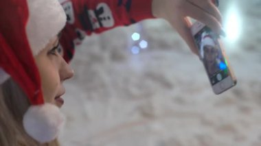 Genç kadın bir Noel selfie için poz.