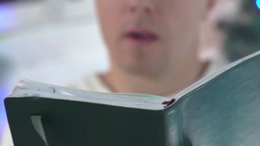 Adam Noel ağacının altında oturup kitap okuyor..