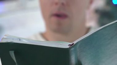 yakışıklı adam Noel hediye olarak kitap bakarak.