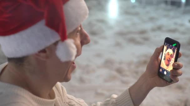 幸せな男でセーターとクリスマスの帽子作りセルフィー — ストック動画