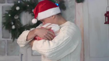 Yetişkin erkek gülümseyen Noel ağacı içinde bir ev yakın duran ve hediyeler holding