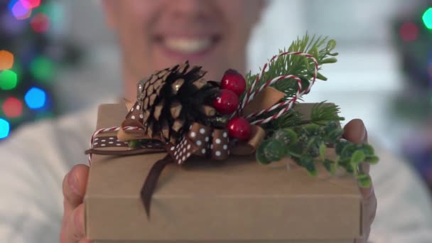 若い男が贈り物をする ギフトボックス明けましておめでとうメリー クリスマス — ストック動画