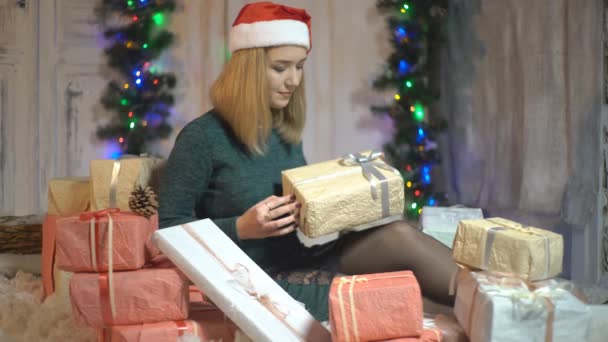 白いスタジオで美しい若い女性がクリスマスTの近くにギフトボックスを保持 — ストック動画