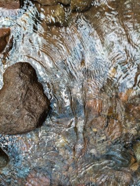 Orman ağaçlarının arasından temiz bir nehir akar. Kesek nehri akışı, büyük kaya, temiz su, Limbangan Şelalesi, Kendal Regency, Central Java, Endonezya.