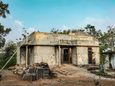 Mavi bulutlu, hafif tuğlaların kullanıldığı evlerin olduğu bir ev inşaatı. Seçici odak.