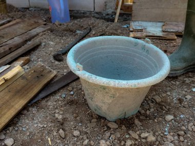 İnşaat alanındaki zeminin dayanıklılığını arttırmak için beton konteynır, kepçeli su, inşaat demirinin dökülmesini bekleyen bir fotoğraf. Seçici odak.