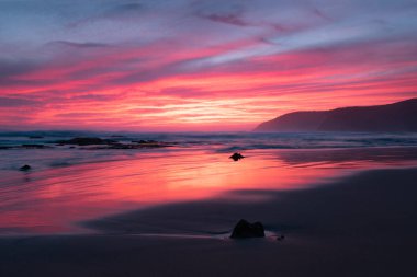 İkonik Great Ocean Road yanında Avustralya bir plaj gün batımında