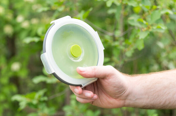 Plastic plate in the hand. Tourist plate. Front view.