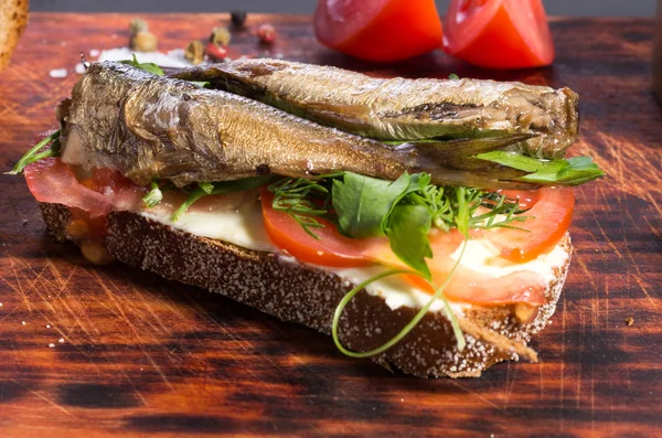 Smoked fish. Sandwich with fish and vegetables. Front view.