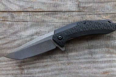 Ahşap arka plan üzerinde Plastik Saplı Bıçak. Çapraz düzenleme.