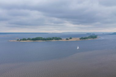 Nehrin ortasında beyaz bir yelkenli. Yalnız bir Yelkenli.