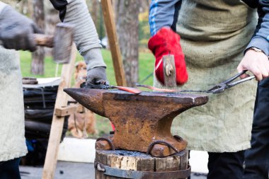 İki adam kızgın demir bıçağı yapılır.