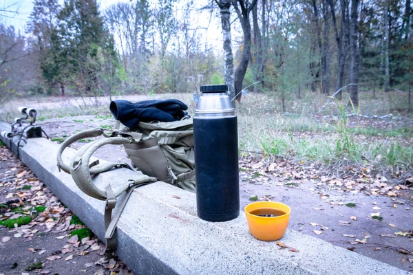 Snack in the forest during the trip. Tea from a thermos while walking through the forest.
