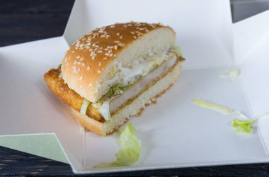 Yarım bir hamburger. Hamburger kesti. Hamburger kutusunda. Önden görünüm.