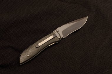 Siyah bir arka plan üzerinde siyah bıçak. Arkadan görünüm. Siyah tekstil.