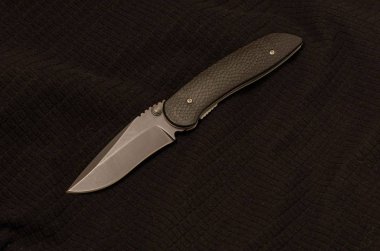 Siyah bir arka plan üzerinde siyah bıçak. Önden görünüm. Blackbackground üzerine siyah. Siyah tekstil.