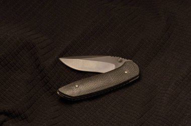 Kavisli şekli bir siyah arka plan üzerine siyah bıçak. Siyah tekstil.