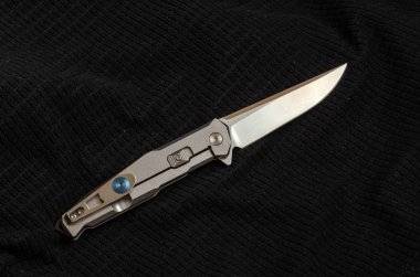 Fotoğraf düşük bir anahtar bir bıçak. Siyah ve beyaz. Demir ve kumaş. Parlatıcı ve gölge. Siyah tekstil.