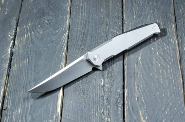 Bir Iron grip ve parlak bıçak bıçak. Siyah ahşap arka plan.