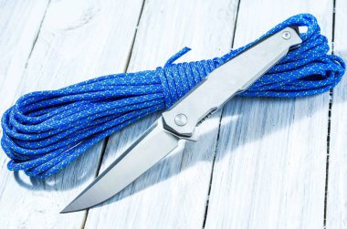 Bir paraşüt kablosunun üzerine parlak bir bıçak. Ön taraf. Beyaz arka plan üzerinde beyaz bıçak.