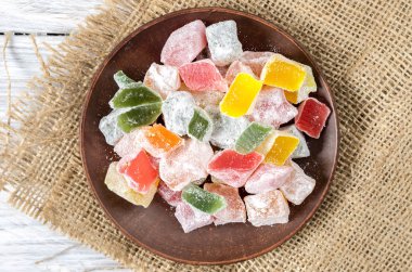 Çok renkli tatlılar bir kil plaka. Üstten görünüm.